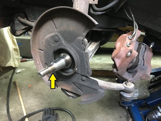 Control arm axle spindle arrow closeup