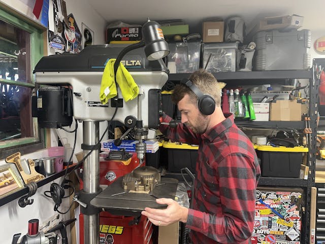 Kyle using drill press with headphones