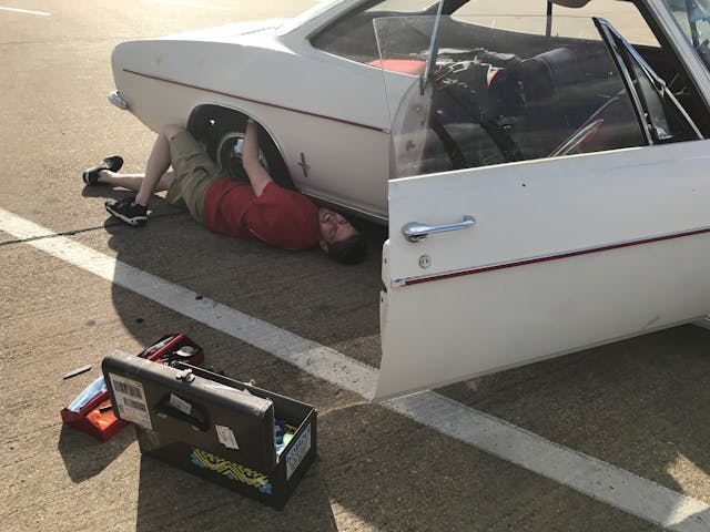 Kyle laying on ground working on Corvair