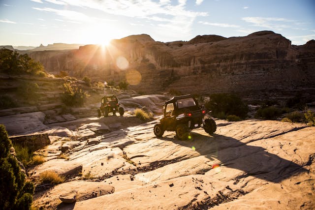 Off road vehicles driving a rock path in Moab