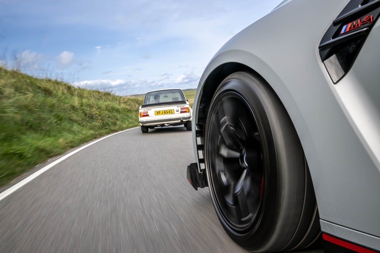 BMW M4 front quarter tracking action behind 2002 Turbo