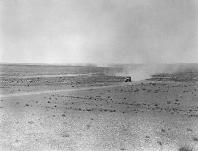 vintage car crossing deserted landscape black white wide