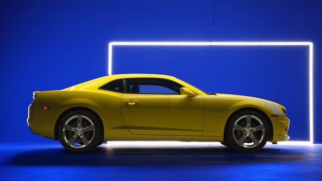 Fifth Gen Camaro yellow side profile blue backdrop studio lighting