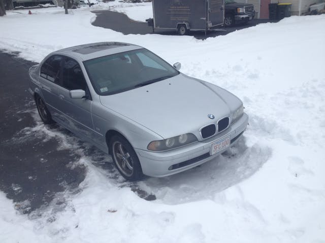 Silver BMW in snow high angle front three quarter