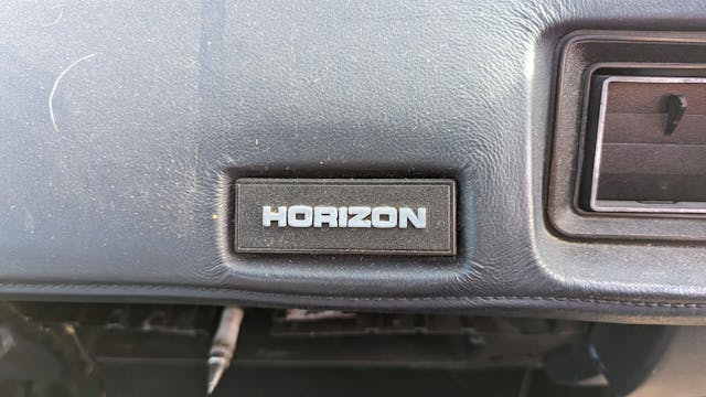 1988 Plymouth Horizon America dash badge closeup