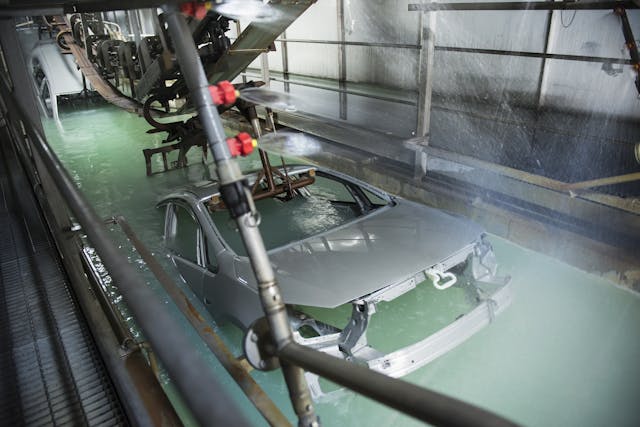 Car bodies being dipped in car factory