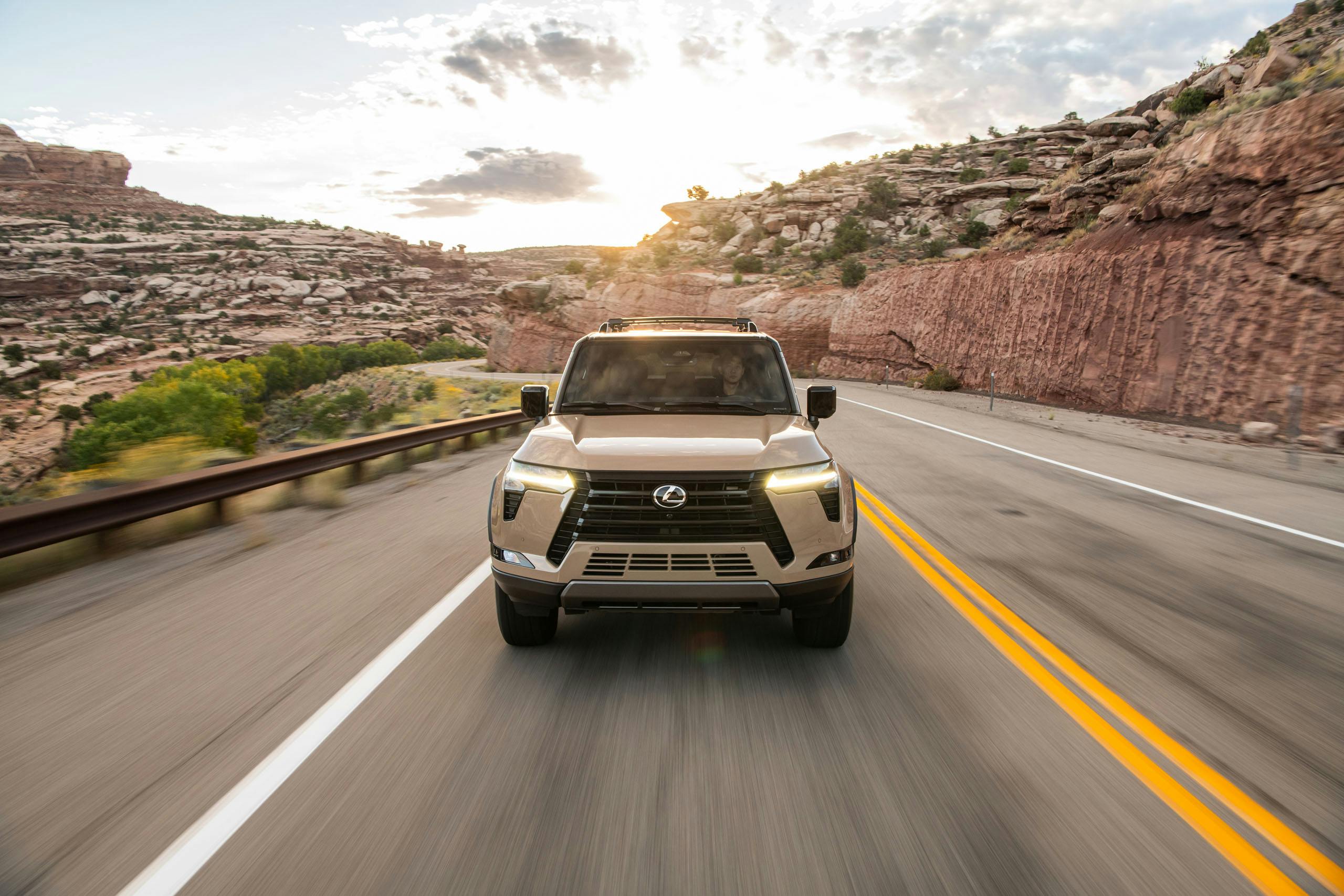 2024 Lexus GX 550 Overtrail+ exterior front end driving on road Earth paint