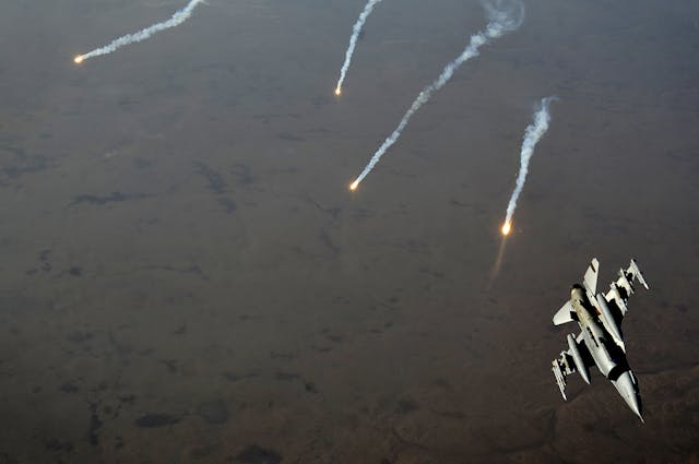 An F-16 Fighting Falcon jet pitches out while popping flares over Iraq