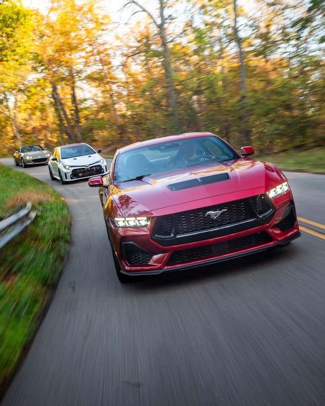 Mustang driving action leading GR Corolla and Mazda Miata