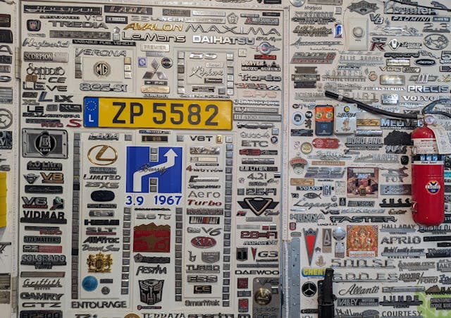 wall of random assorted automotive badges