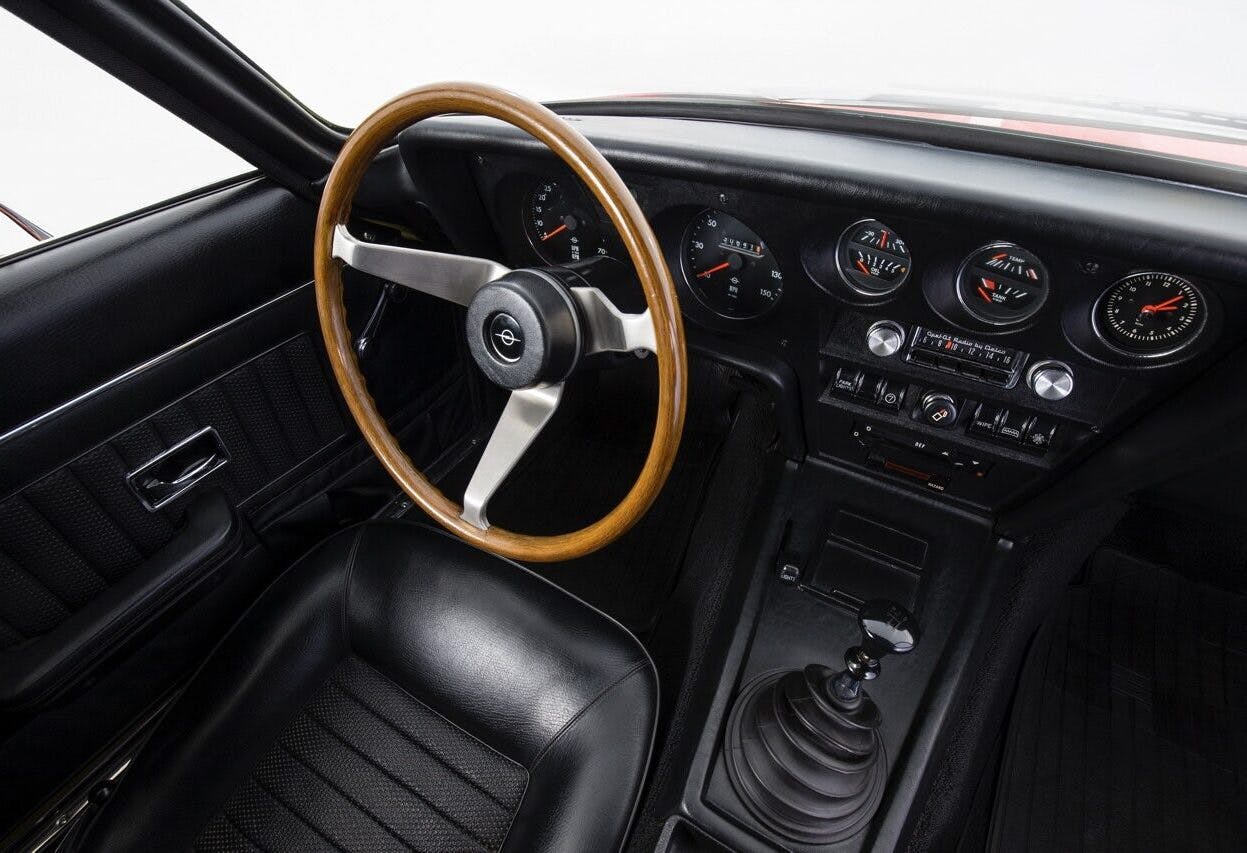 The interior boasts bucket seats, round instruments and a three-spoke steering wheel