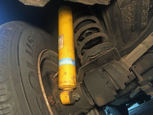 Bilstein shock tube yellow closeup installed in used SUV