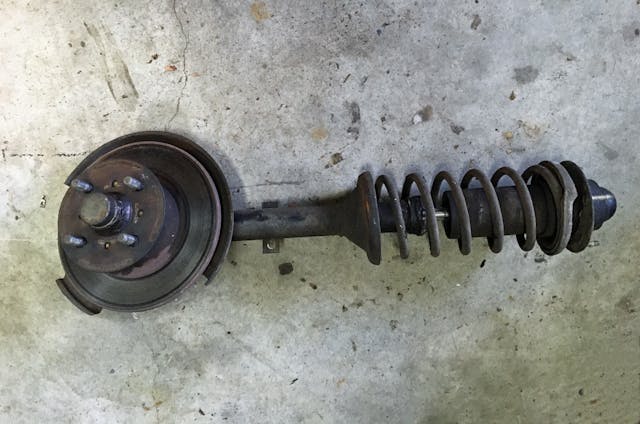 Nissan Armada used bad strut tower and hub removed laying on garage floor