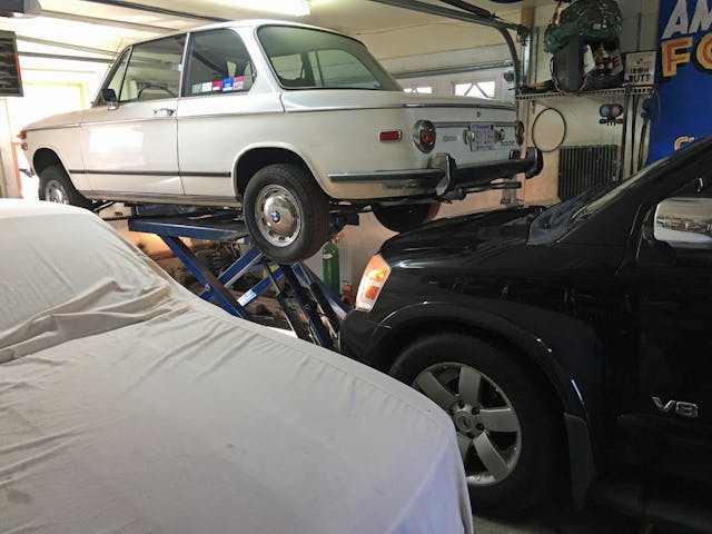 DIY exhaust repair parking nissan armada underneath vintage bmw as close as possible