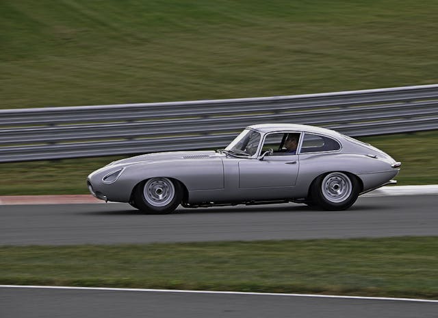 Silver jaguar on track action side view