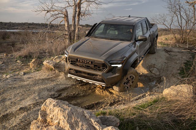 2024 Toyota Tacoma Trailhunter exterior high front three quarter angled in rocks and mud