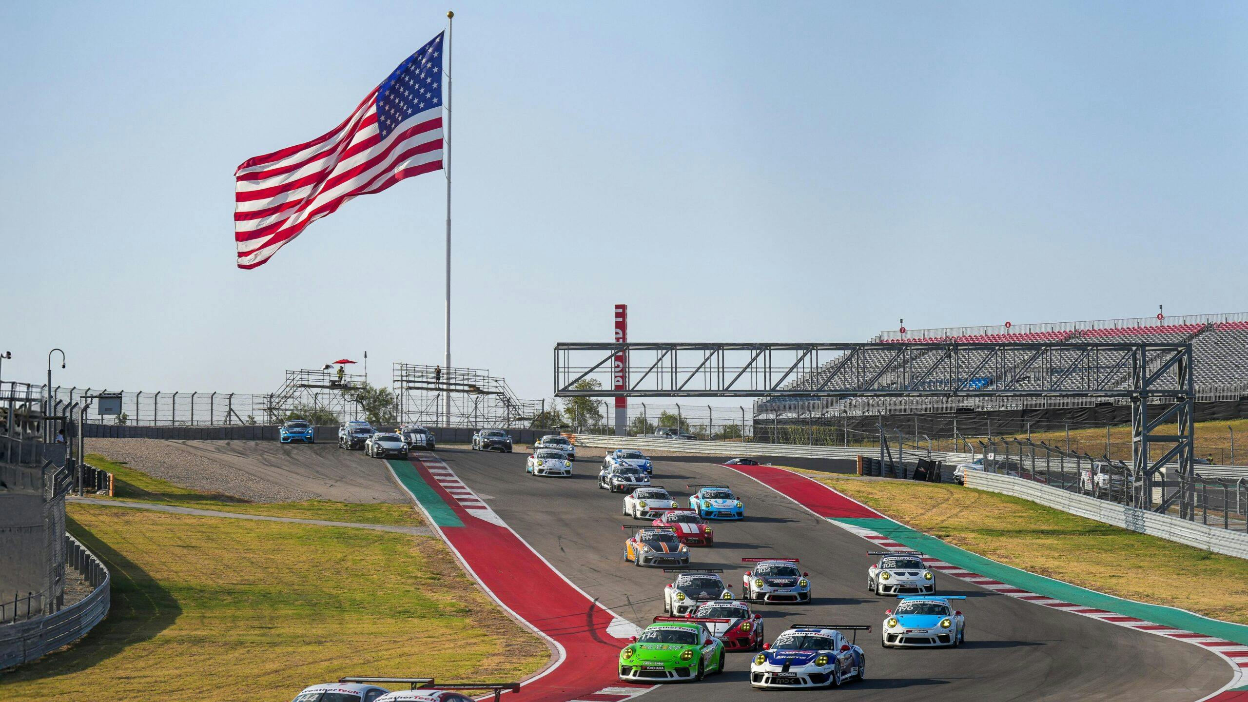 Porsche Endurance Challenge North America COTA 911 Cup cars on track big American flag