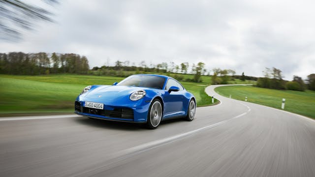 2025 Porsche 911 Carrera Coupe exterior front three quarter driving on road blue