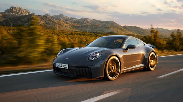 2025 Porsche 911 Carrera GTS Coupe exterior grey front three quarter driving on road at golden hour