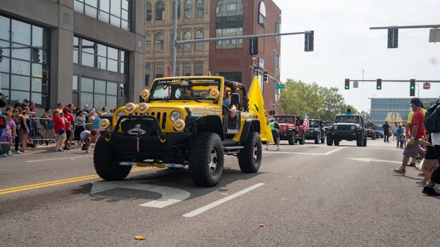 Duck Duck Jeep Toledo Jeepfest yellow Wrangler with smiley lights in parade