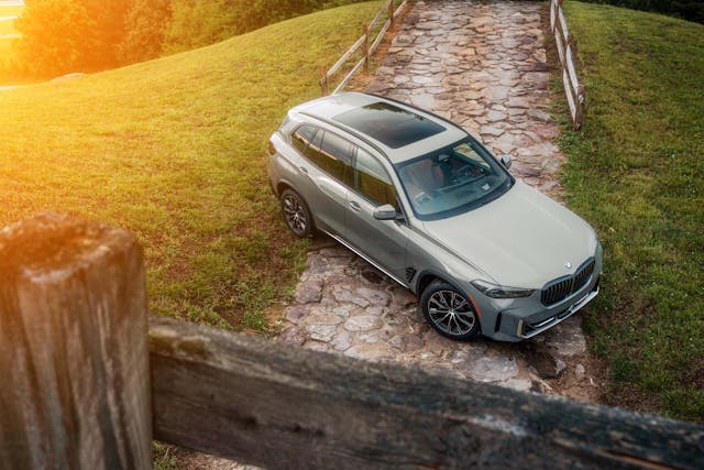 2025 BMW X5 Silver Anniversary Edition exterior high front three quarter on rocks