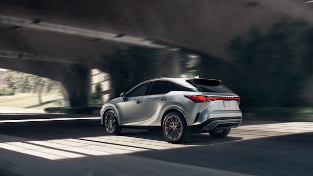2024 Lexus RX 450h+ exterior rear three quarter driving silver