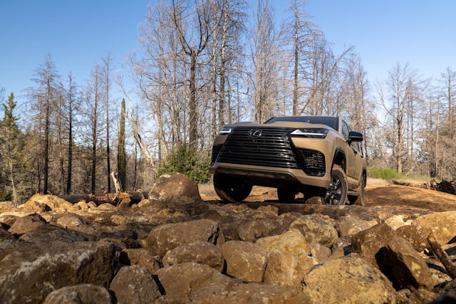 2025 Lexus LX 700h Overtrail off-roading exterior front end low going over rock garden