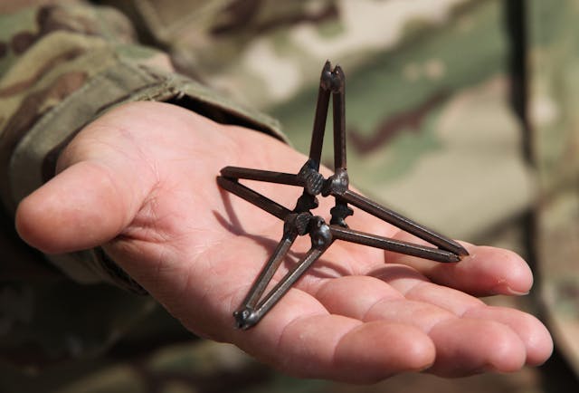 Border security caltrop in hand