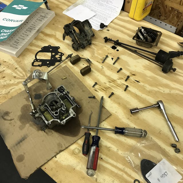 Corvair carb apart on workbench
