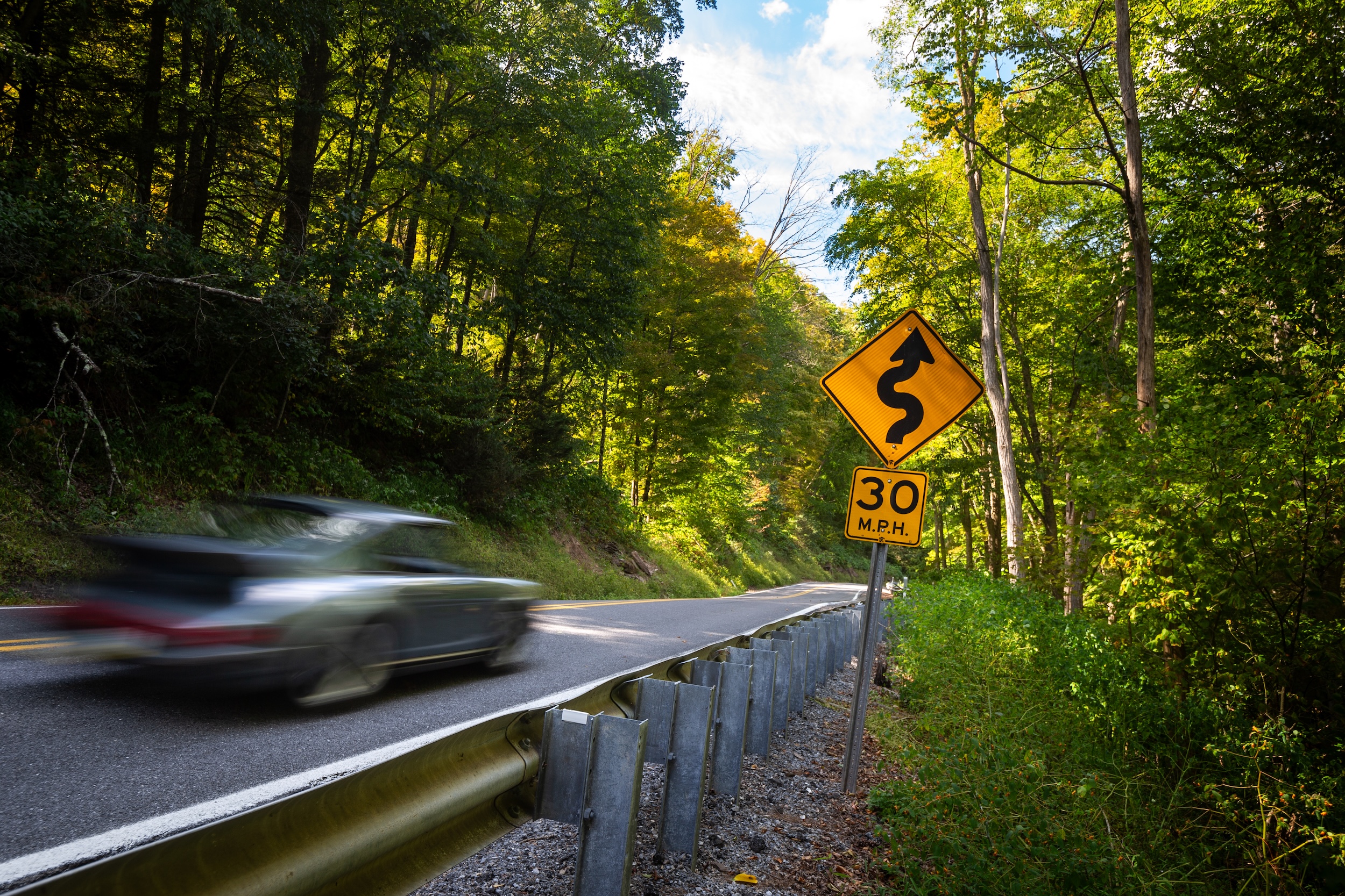 1983 Porsche 911SC blur curving road sign